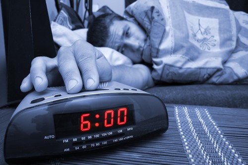 student hitting alarm clock